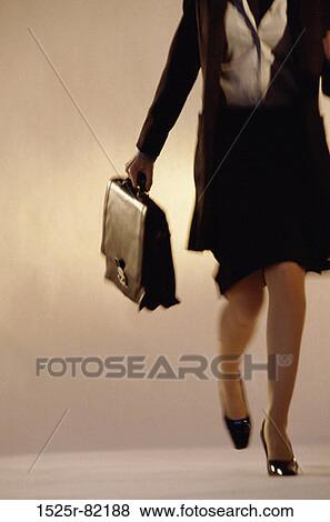 Portrait of a businesswoman walking holding a briefcase View Large Photo Image Stock Photo - Portrait of a businesswoman walking holding a briefcase. Fotosearch