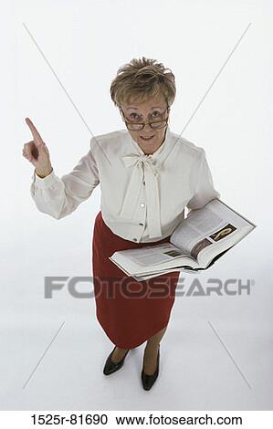 Portrait of a female teacher holding a book View Large Photo Image Stock Image - Portrait of a female teacher holding a book. Fotosearch