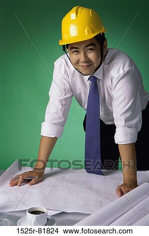 Portrait of a foreman wearing a hardhat leaning on blueprints View Large Photo Image Picture - Portrait of a foreman wearing a hardhat leaning on blueprints. Fotosearch