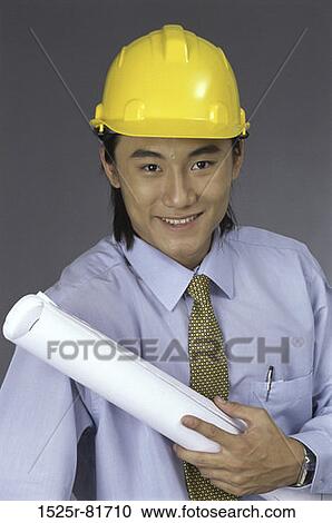 Portrait of a foreman wearing a hardhat holding a blueprint View Large Photo Image Stock Image - Portrait of a foreman wearing a hardhat holding a blueprint. Fotosearch