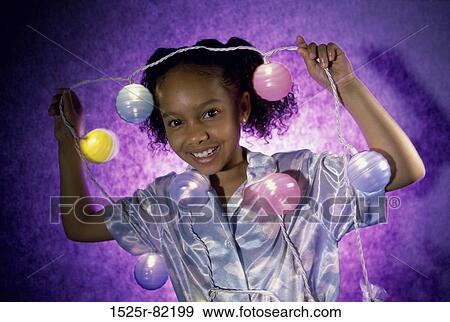Stock Photo - Portrait of a girl holding a string of colored lights. Fotosearch