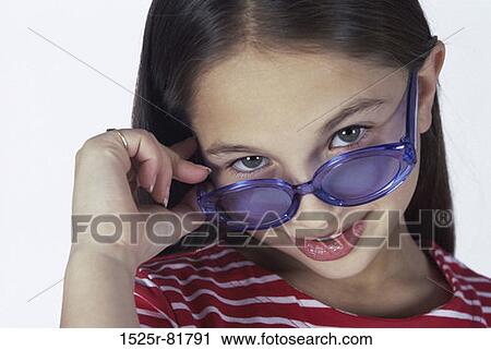 Stock Image - Portrait of a girl wearing sunglasses smiling. Fotosearch