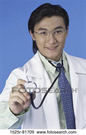 Portrait of a male doctor holding a stethoscope View Large Photo Image Stock Photo - Portrait of a male doctor holding a stethoscope. Fotosearch