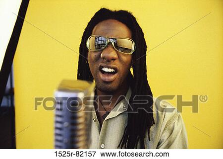 Portrait of a man singing into a microphone View Large Photo Image Stock Photo - Portrait of a man singing into a microphone. Fotosearch