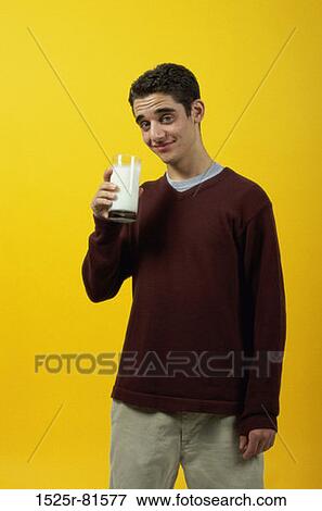 Portrait of a teenage boy holding a glass of milk View Large Photo Image Stock Photo - Portrait of a teenage boy holding a glass of milk. Fotosearch