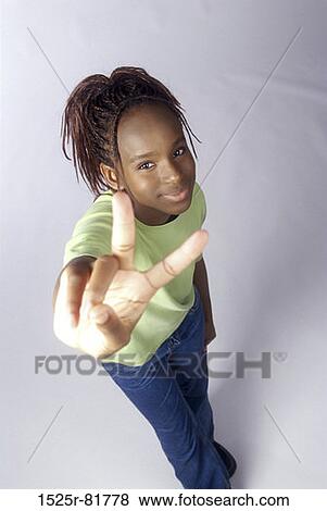 Stock Photo - Portrait of a teenage girl making the victory sign. Fotosearch