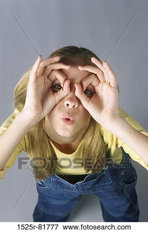 Stock Photo - Portrait of a teenage girl pretending to wear eyeglasses. Fotosearch