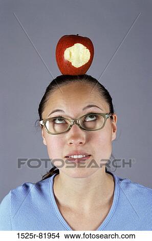 Picture - Portrait of a woman balancing an eaten apple on her head. Fotosearch