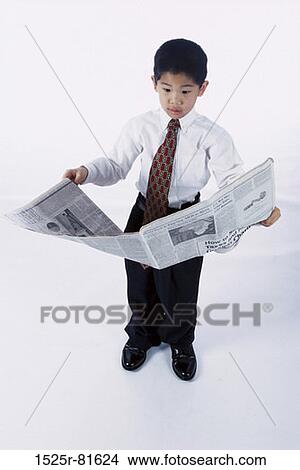 Portrait of a young boy dressed as a businessman reading a newspaper View Large Photo Image Picture - Portrait of a young boy dressed as a businessman reading a newspaper. Fotosearch