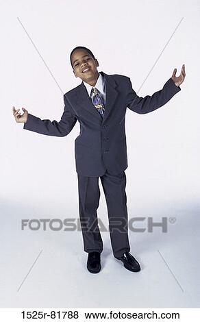 Portrait of a young boy dressed as a businessman standing with his arms raised to the side View Large Photo Image Stock Photo - Portrait of a young boy dressed as a businessman standing with his arms raised to the side. Fotosearch