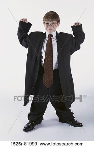Stock Photo - Portrait of a young boy dressed as a businessman with his arms raised. Fotosearch