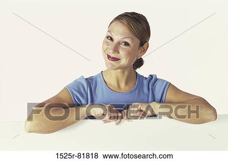 Stock Photo - Portrait of a young woman behind a wall. Fotosearch