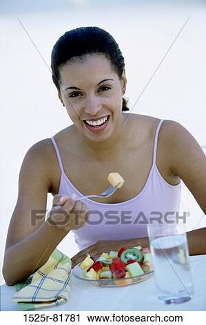 Portrait of a young woman eating a fruit salad View Large Photo Image Stock Image - Portrait of a young woman eating a fruit salad. Fotosearch