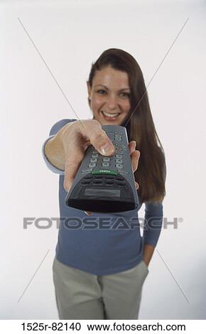 Portrait of a young woman holding a remote control View Large Photo Image Stock Image - Portrait of a young woman holding a remote control. Fotosearch