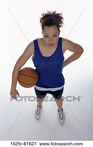 Stock Photo - Portrait of a young woman holding a basketball. Fotosearch