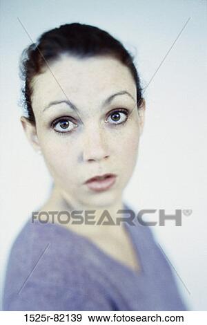 Stock Photo - Portrait of a young woman looking surprised. Fotosearch