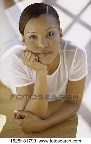 Stock Photo - Portrait of a young woman lying on the floor. Fotosearch
