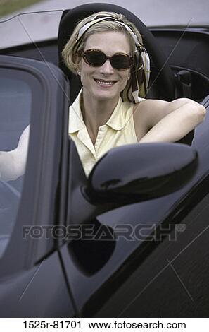 Portrait of a young woman sitting in a convertible car View Large Photo Image Stock Image - Portrait of a young woman sitting in a convertible car. Fotosearch