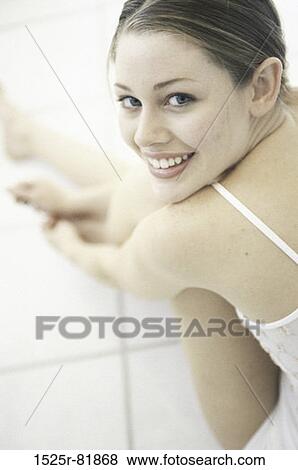 Portrait of a young woman sitting on the floor View Large Photo Image Stock Photo - Portrait of a young woman sitting on the floor. Fotosearch