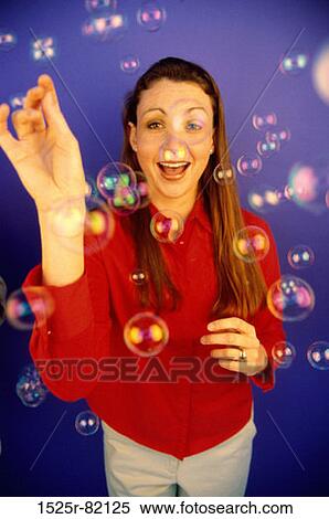 Portrait of a young woman standing among soap bubbles View Large Photo Image Stock Photography - Portrait of a young woman standing among soap bubbles. Fotosearch