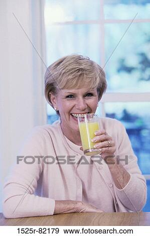 Portrait of an elderly woman drinking a glass of orange juice View Large Photo Image Stock Photo - Portrait of an elderly woman drinking a glass of orange juice. Fotosearch