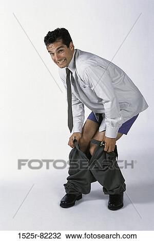 Stock Image - Portrait of businessman pulling up his pants. Fotosearch