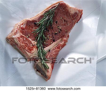 Stock Image - Raw beef with rosemary. Fotosearch