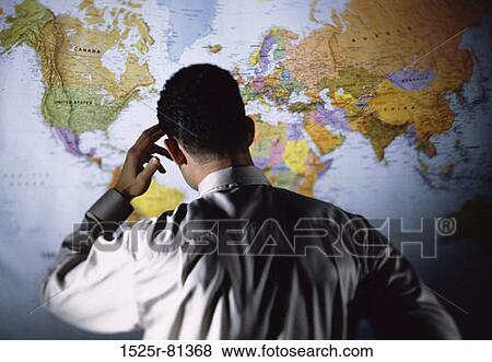 Rear view of a businessman in front of a map View Large Photo Image Stock Photo - Rear view of a businessman in front of a map. Fotosearch