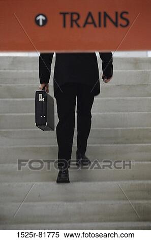 Stock Photography - Rear view of a businessman walking up stairs. Fotosearch