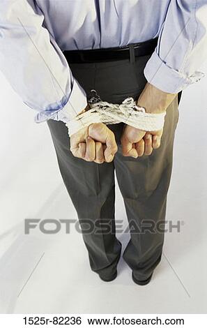 Rear view of a businessman with his hands tied behind his back View Large Photo Image Stock Photograph - Rear view of a businessman with his hands tied behind his back. Fotosearch
