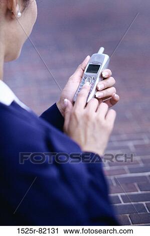 Rear view of a businesswoman operating a mobile phone View Large Photo Image Stock Image - Rear view of a businesswoman operating a mobile phone. Fotosearch