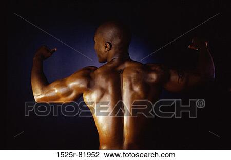 Stock Image - Rear view of a young man flexing his biceps. Fotosearch