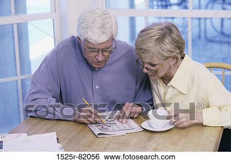 Stock Photograph - Senior couple solving a crossword puzzle. Fotosearch
