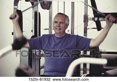 Stock Image - Senior man exercising on a machine. Fotosearch