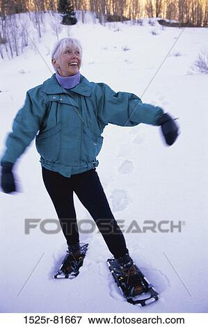 Senior woman standing in snow smiling View Large Photo Image Stock Photo - Senior woman standing in snow smiling. Fotosearch