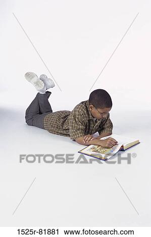 Side profile of a boy lying on the ground reading a book View Large Photo Image Stock Image - Side profile of a boy lying on the ground reading a book. Fotosearch