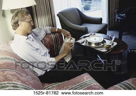 Side profile of a businessman sitting on a couch in a hotel room View Large Photo Image Stock Image - Side profile of a businessman sitting on a couch in a hotel room. Fotosearch