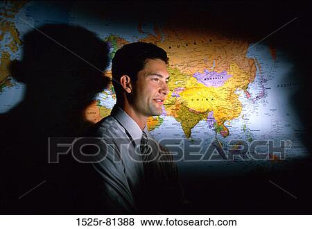 Side profile of a businessman standing in front of a map View Large Photo Image Stock Photo - Side profile of a businessman standing in front of a map. Fotosearch
