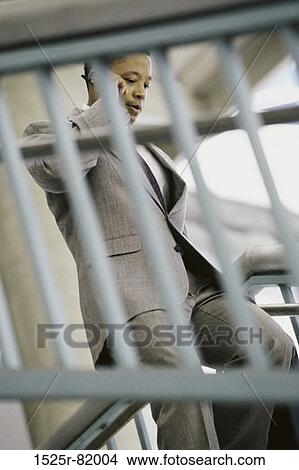 Picture - Side profile of a businessman talking on a mobile phone. Fotosearch