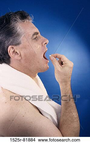 Side profile of a man taking a pill View Large Photo Image Picture - Side profile of a man taking a pill. Fotosearch