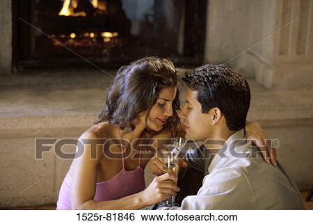 Stock Photograph - Side profile of a young couple by the fireplace. Fotosearch