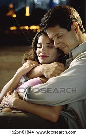 Side profile of a young couple holding each other View Large Photo Image Picture - Side profile of a young couple holding each other. Fotosearch