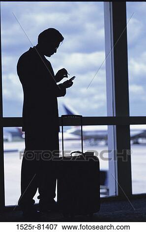 Silhouette of a businessman standing in an airport View Large Photo Image Stock Photo - Silhouette of a businessman standing in an airport. Fotosearch