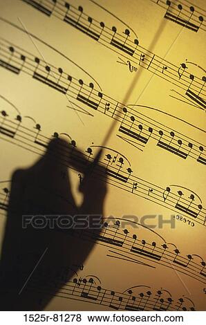 Silhouette of a hand conducting over sheet music View Large Photo Image Stock Photo - Silhouette of a hand conducting over sheet music. Fotosearch