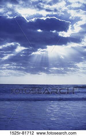 Sunbeams shining through clouds over an ocean View Large Photo Image Stock Image - Sunbeams shining through clouds over an ocean. Fotosearch