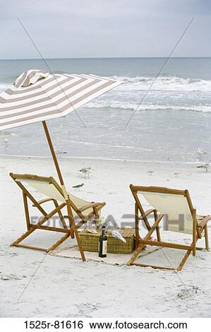 Stock Photograph - Two deck chairs and an umbrella on the beach. Fotosearch