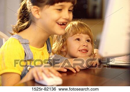 Two girls in front of a computer monitor View Large Photo Image Stock Photograph - Two girls in front of a computer monitor. Fotosearch