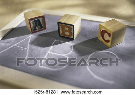 Stock Image - Wooden alphabet blocks on a chalkboard. Fotosearch