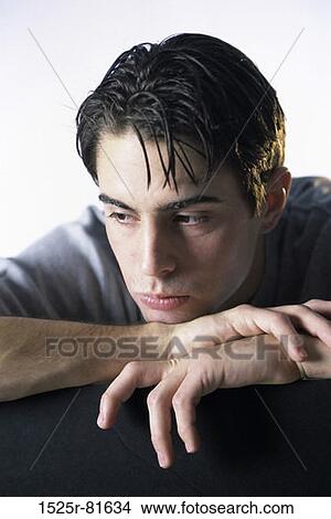 Young man resting his chin on his hands View Large Photo Image Picture - Young man resting his chin on his hands. Fotosearch