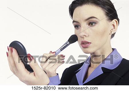 Stock Image - Young woman applying make-up. Fotosearch
